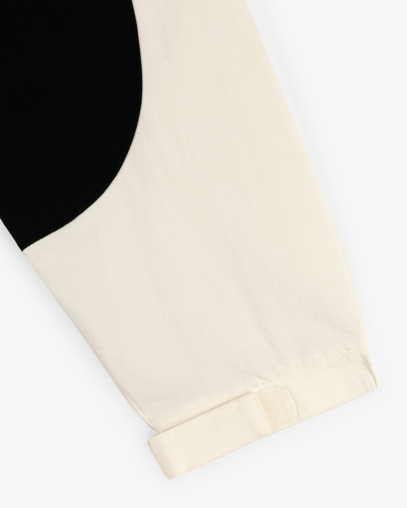 A close-up of the Crest Nylon Half-Zip Pullover, featuring a black and cream color block with a cuffed cream sleeve.