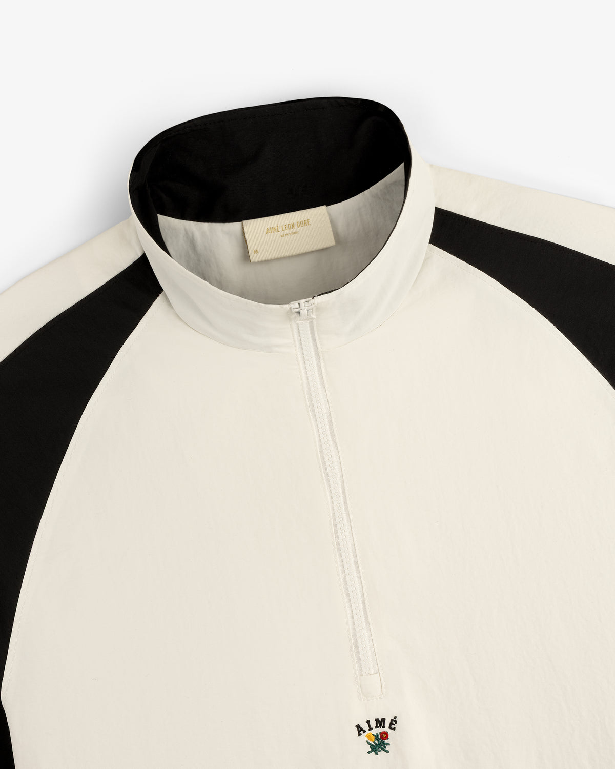 White and black Crest Nylon Half-Zip Pullover with a high collar and small embroidered logo by the zipper.