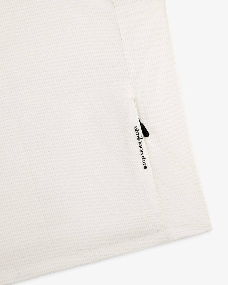 Close-up of the ALD Golf Lightweight Tips Windbreaker with a zippered pocket and branded zipper pull.