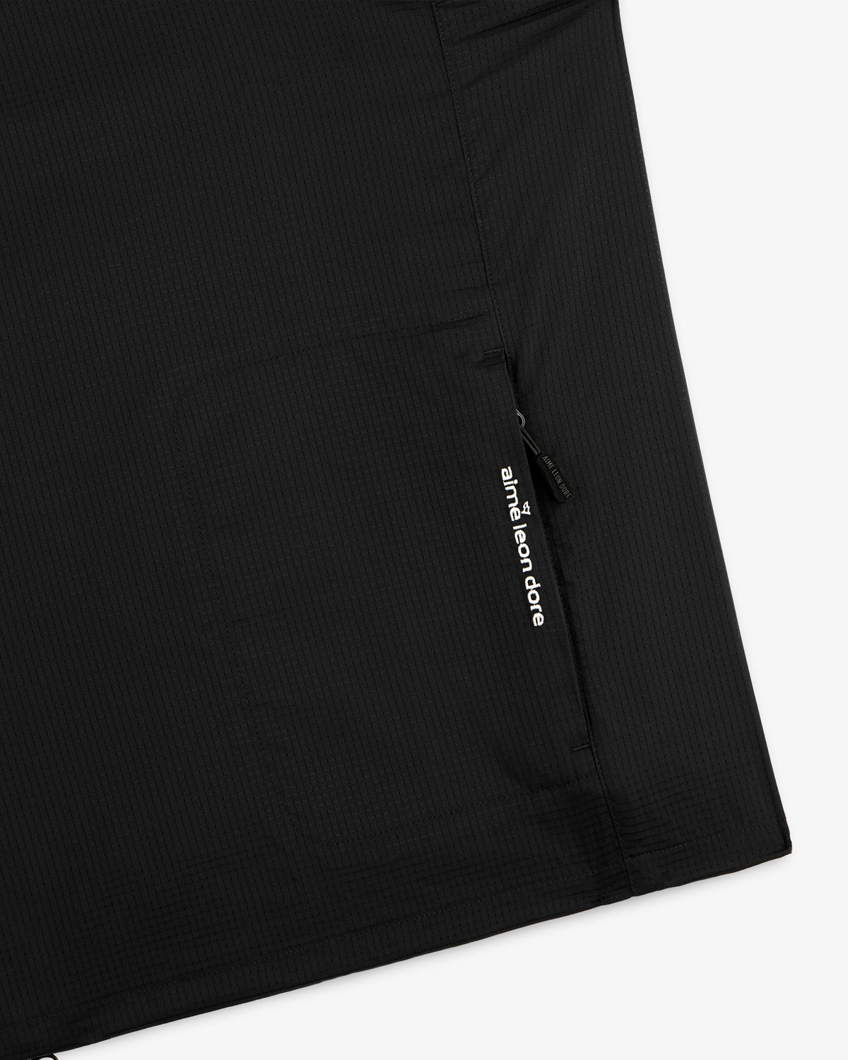 Close-up of a black ALD Golf Lightweight Tips Windbreaker pocket with a zipper and white Aimé Leon Dore text.