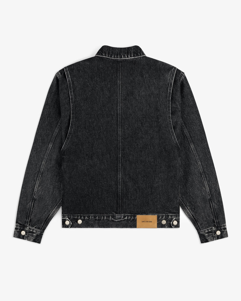 Denim Trucker Jacket in black, shown from the back with white stitching and a brown label near the hem.