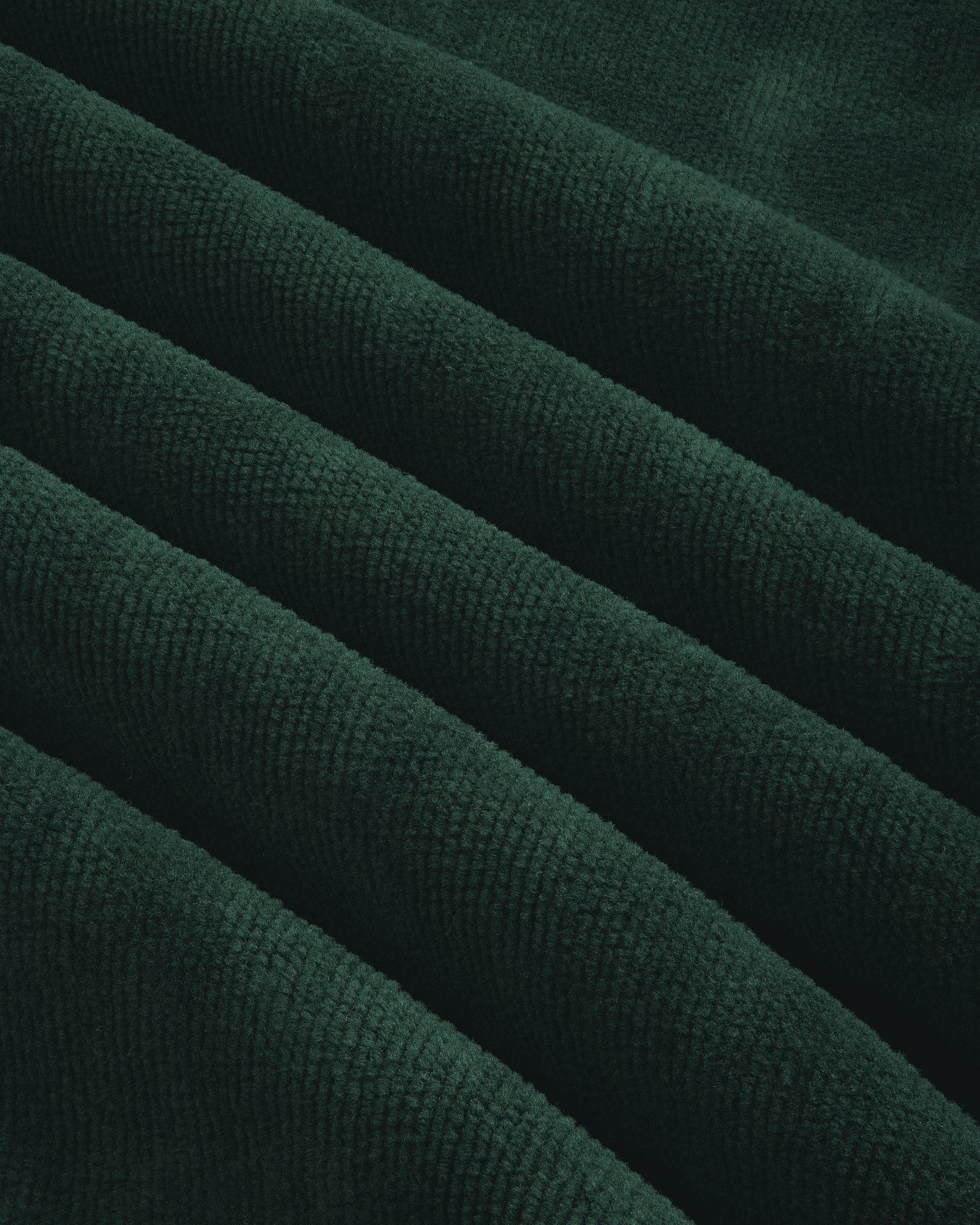 Close-up of Mulberry Robe's dark green corduroy, showcasing its visible ridges and soft texture.