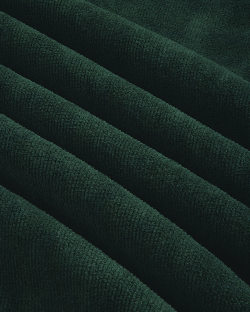 Close-up of Mulberry Robe's dark green corduroy, showcasing its visible ridges and soft texture.