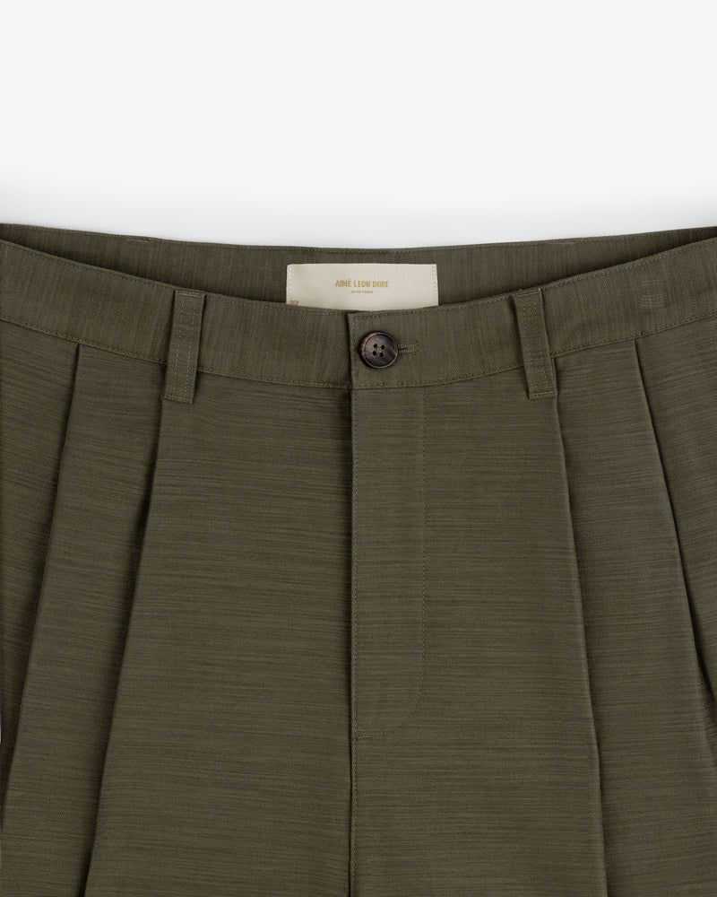 Close-up of Double Pleated Pant in olive green, highlighting the button, waistband, and front upper section.