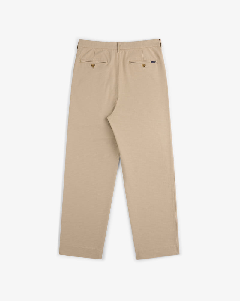 Double Pleated Pant in beige, shown from the back with two buttoned rear pockets and a straight leg cut.