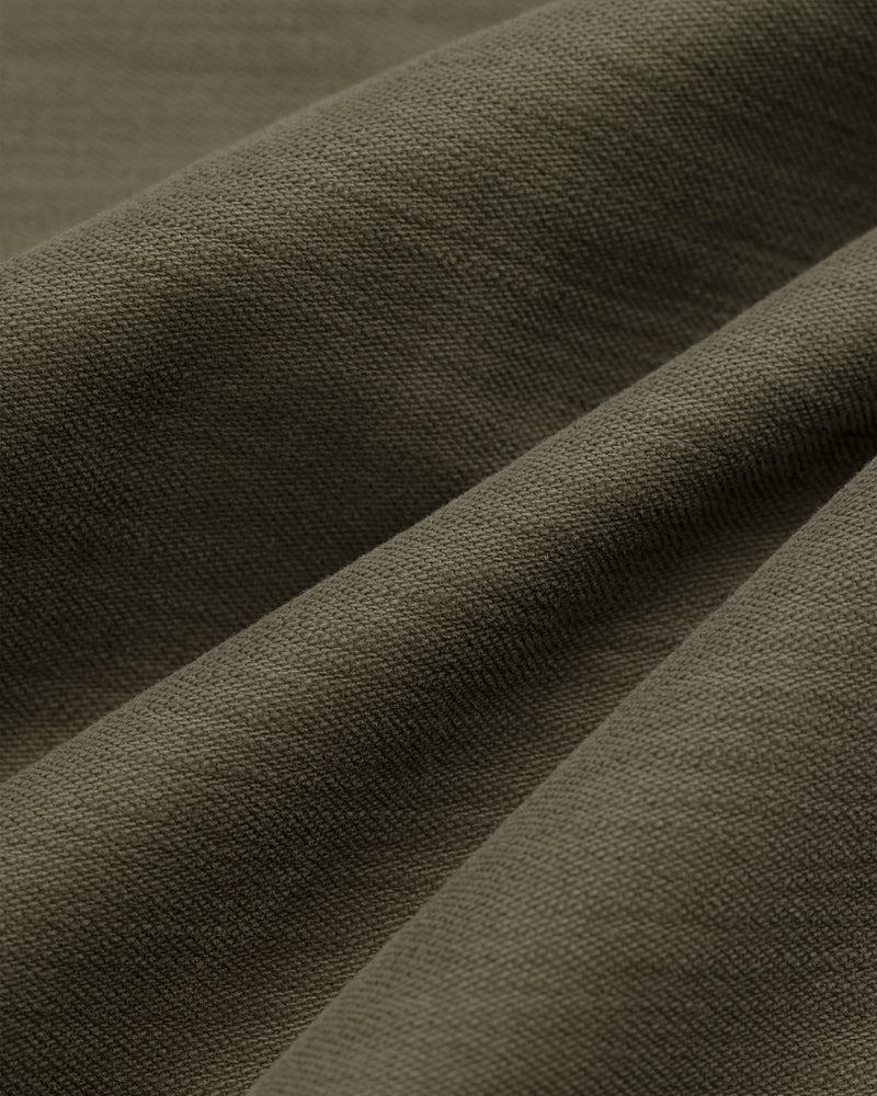 Close-up of olive green Double Pleated Pant showing textured fabric with gentle folds and visible weave pattern.