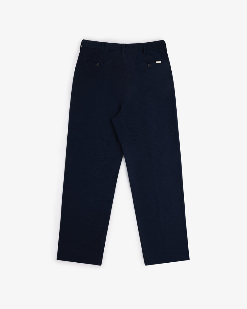 Double Pleated Pant in navy blue, shown from the back with two back pockets and a straight-leg fit.