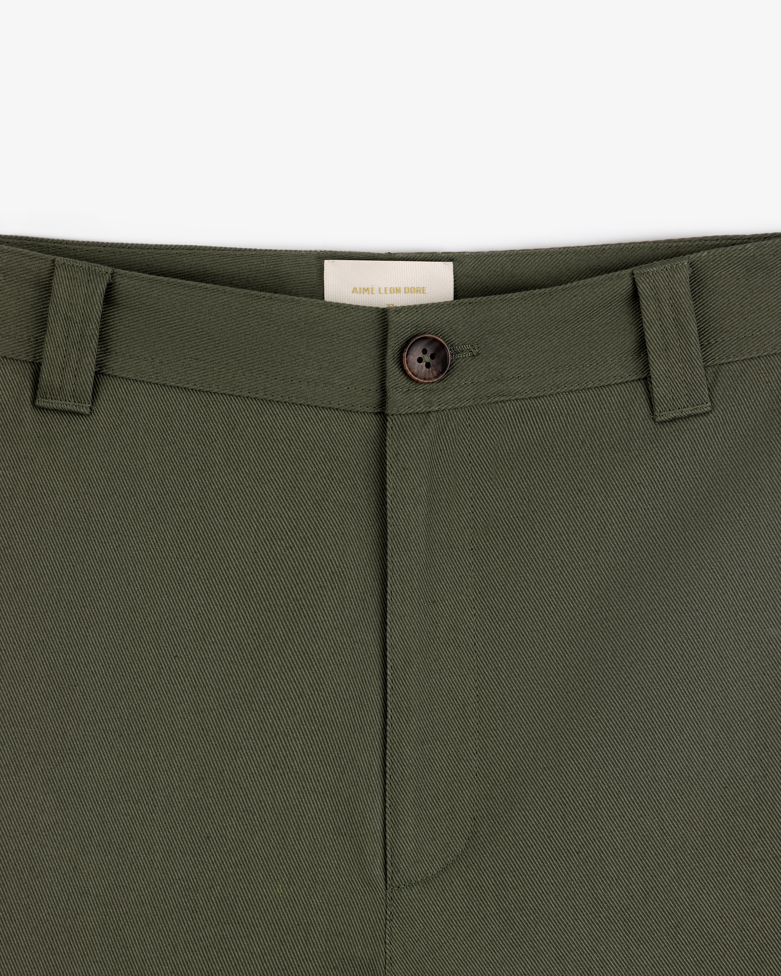Close-up of Officer Pant in olive green with button closure and belt loops, shown from waist to upper thigh.