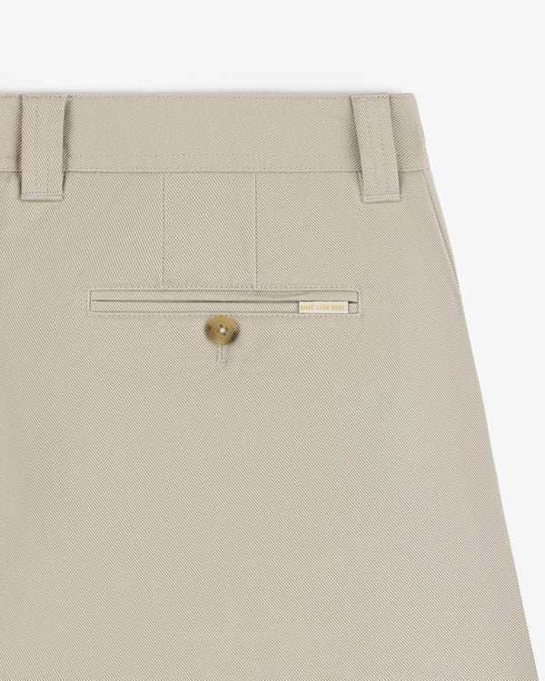 Close-up of Officer Pant in beige, featuring a back pocket with button and belt loops at the waistband.