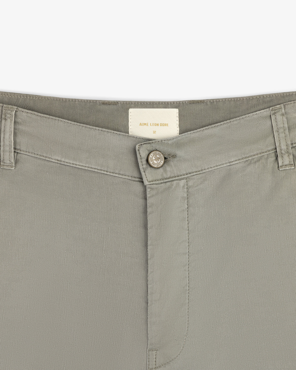 Close-up of the waistband and button of Linen Blend Carpenter Pant in light gray with belt loops and inside brand label.