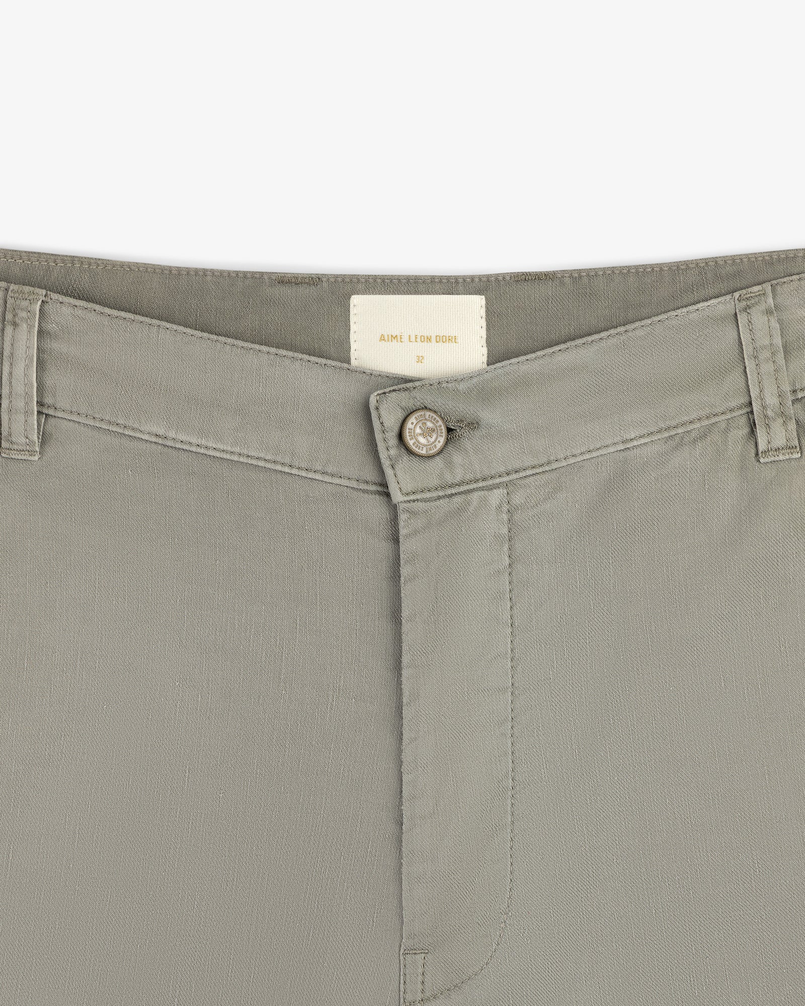 Close-up of the waistband and button of Linen Blend Carpenter Pant in light gray with belt loops and inside brand label.