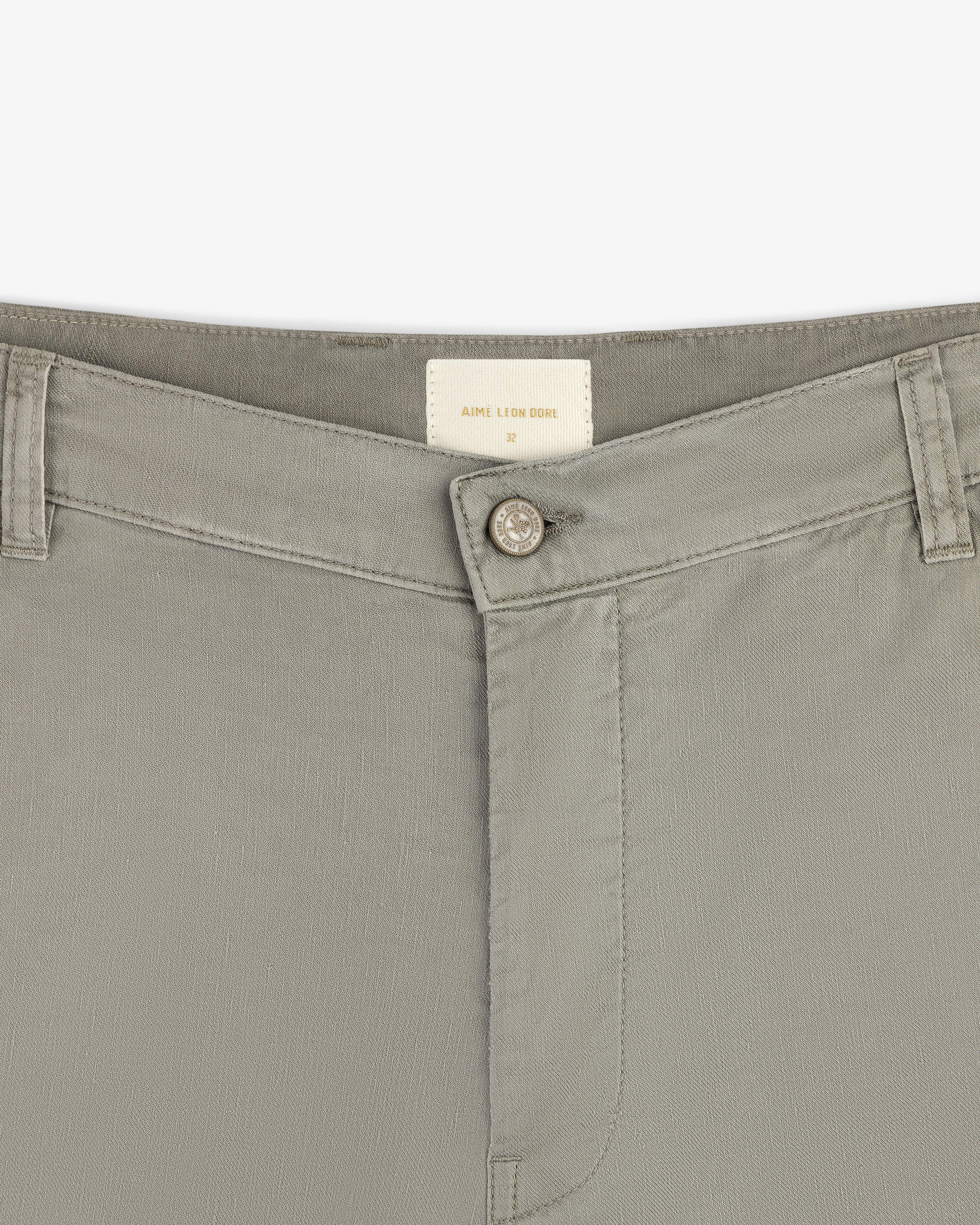 Close-up of the waistband and button of Linen Blend Carpenter Pant in light gray with belt loops and inside brand label.