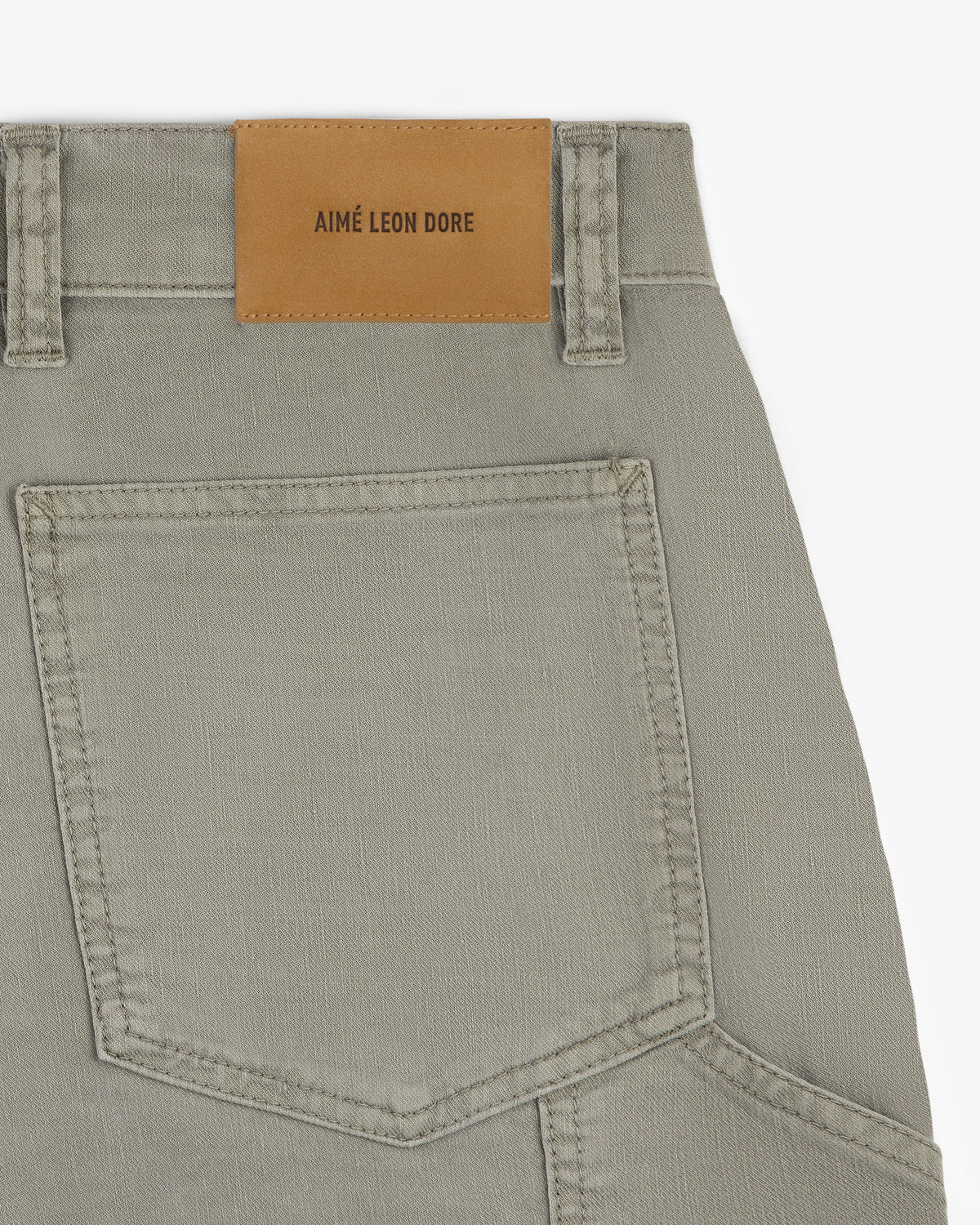 Close-up of Linen Blend Carpenter Pant in beige, showing a back pocket and AIMÉ LEON DORE leather patch on waistband.