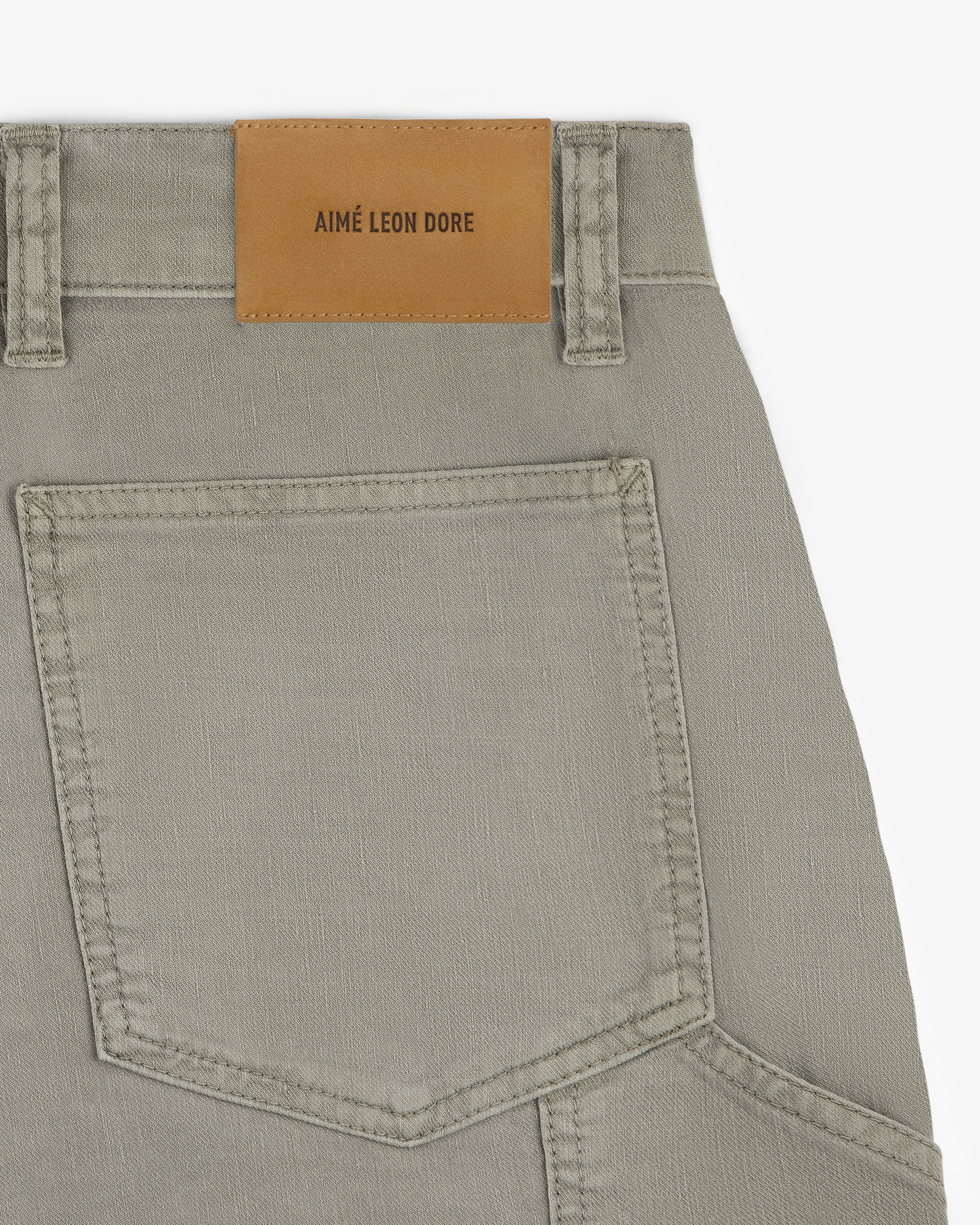 Close-up of Linen Blend Carpenter Pant in beige, showing a back pocket and AIMÉ LEON DORE leather patch on waistband.
