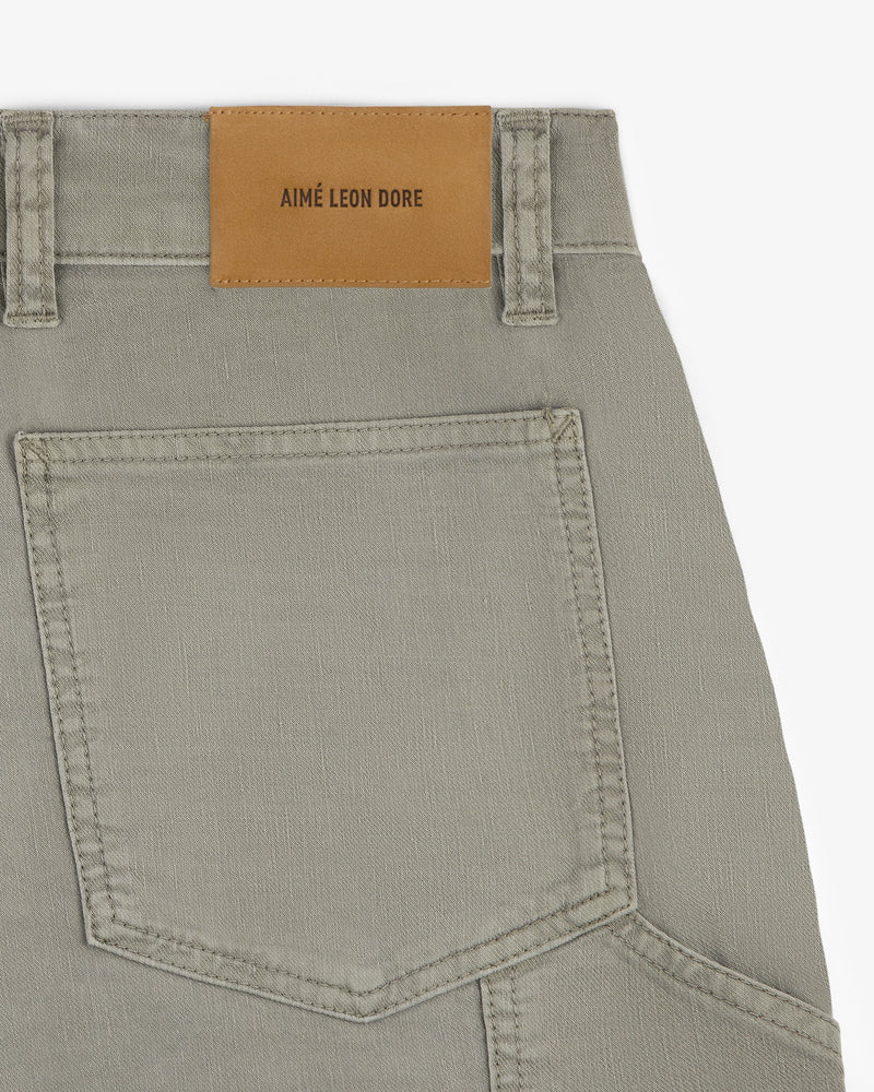 Close-up of Linen Blend Carpenter Pant in beige, showing a back pocket and AIMÉ LEON DORE leather patch on waistband.
