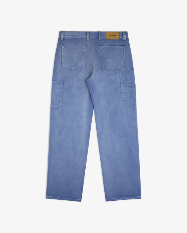 Linen Blend Carpenter Pant in light blue denim shown from the back with large square pockets and a tan waistband patch.