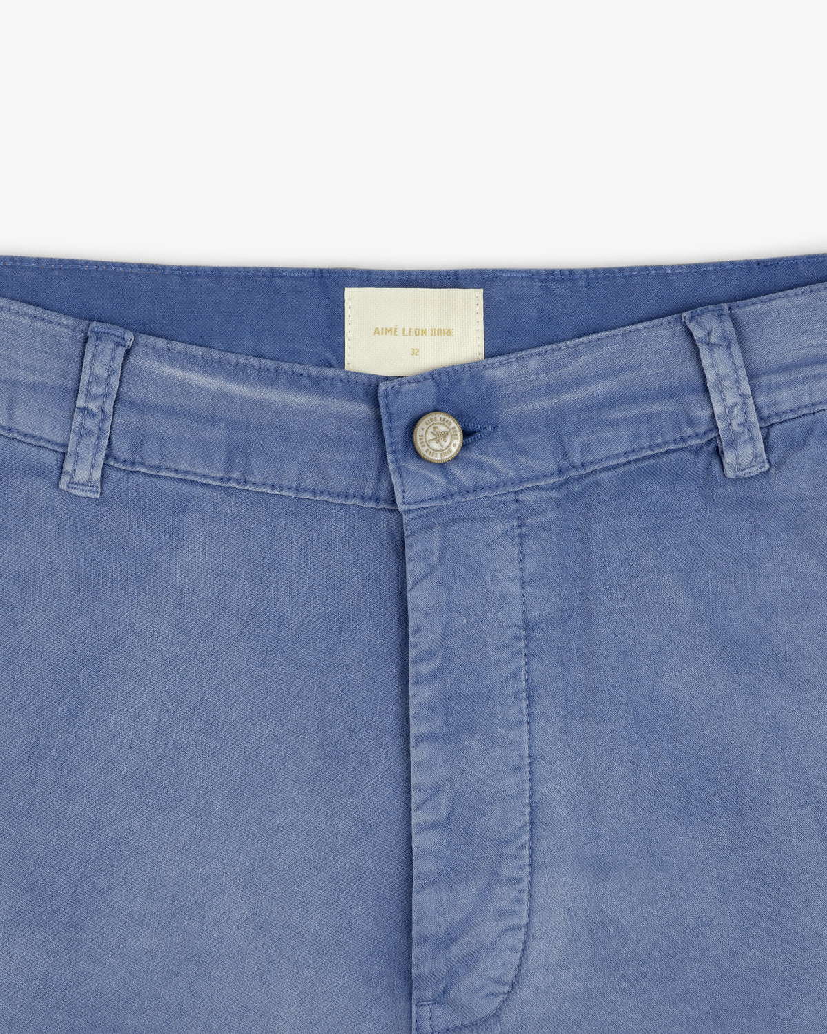 Close-up of the waistband and button on Linen Blend Carpenter Pant in light blue with belt loops and a white inside label.