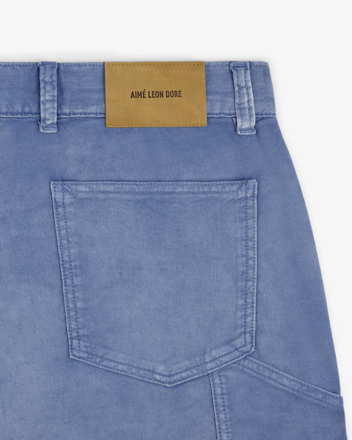 Close-up of light blue Linen Blend Carpenter Pant with a tan leather Aimé Leon Dore patch above the back pocket.