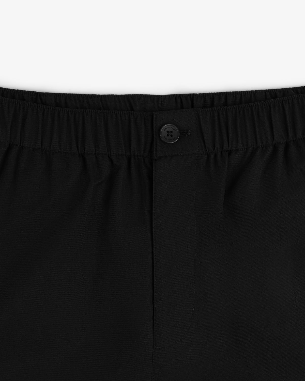 Close-up of the waistband on the Relaxed Cotton Trouser, featuring an elastic band and a single black button at the center.