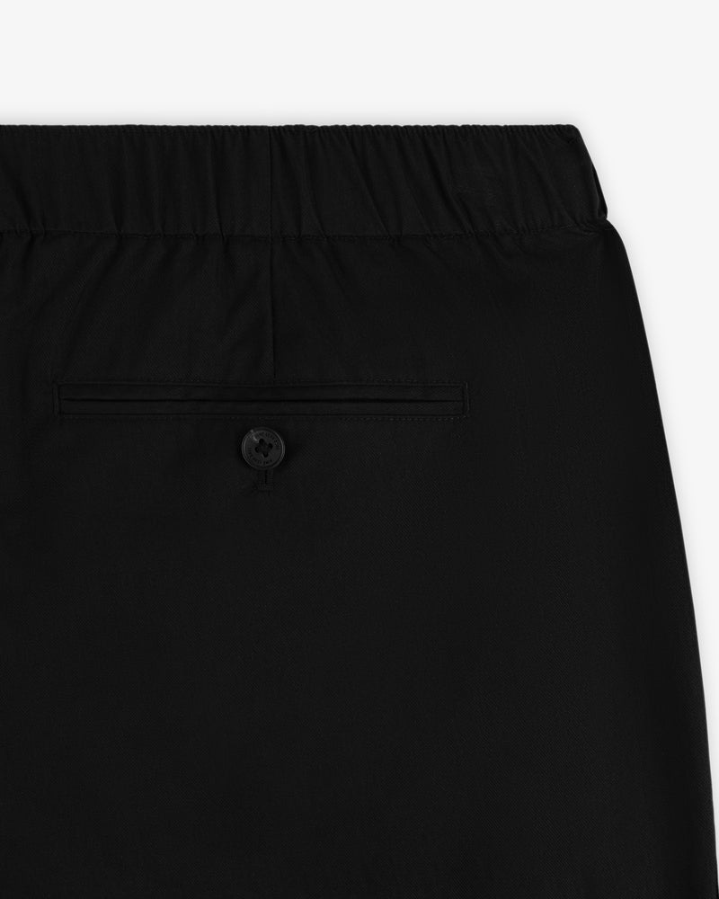 Close-up of Relaxed Cotton Trouser in black with elastic waistband and a single-button back pocket.
