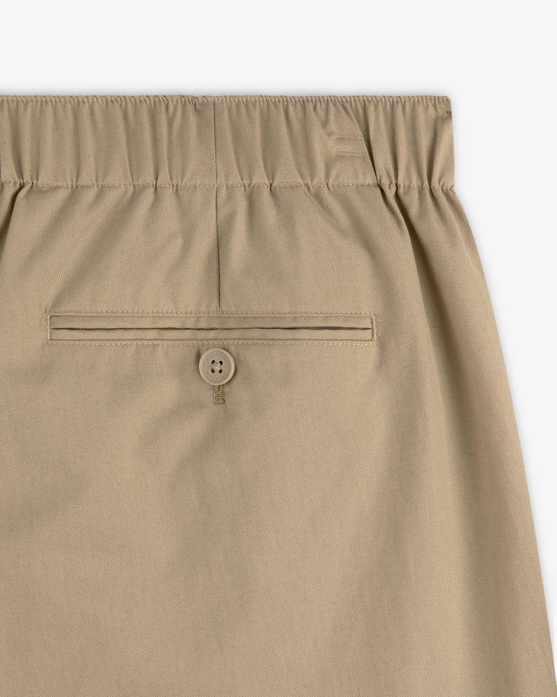 Close-up of Relaxed Cotton Trouser in beige with elastic waistband and back pocket featuring a button closure.
