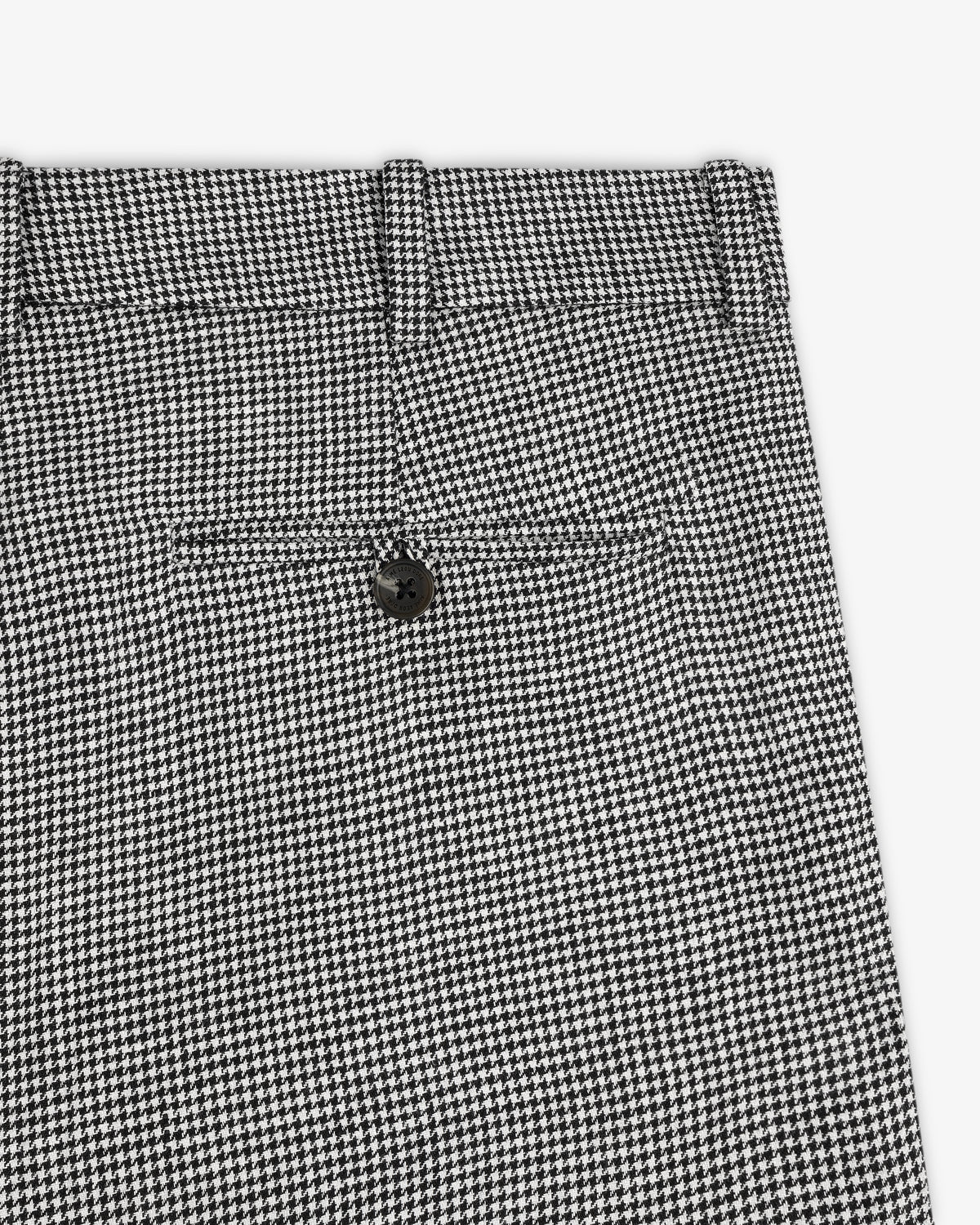 Close-up of Houndstooth Pleated Trouser in black and white with back pocket and black button.