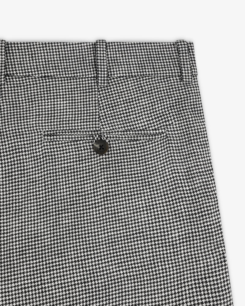 Close-up of Houndstooth Pleated Trouser in black and white with back pocket and black button.
