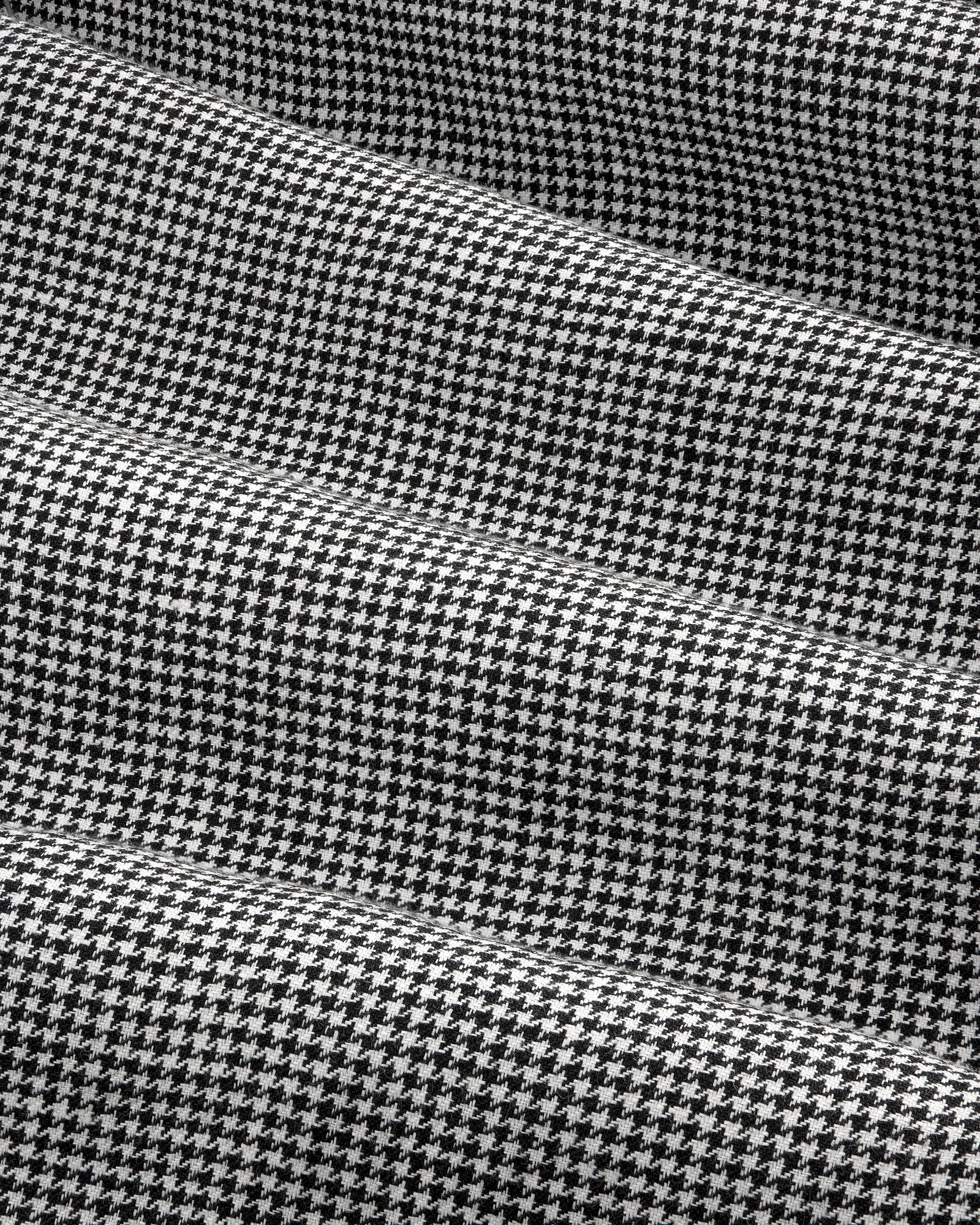 Close-up of Houndstooth Pleated Trouser in black and white with subtle horizontal folds in the fabric.