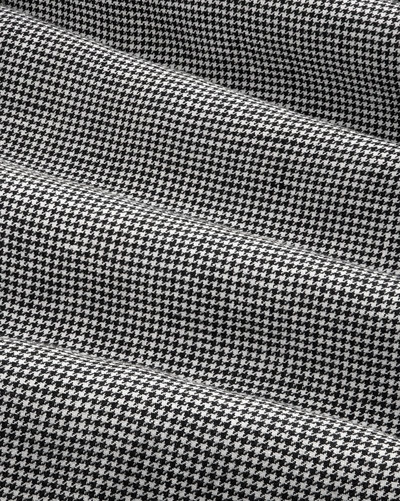 Close-up of Houndstooth Pleated Trouser in black and white with subtle horizontal folds in the fabric.
