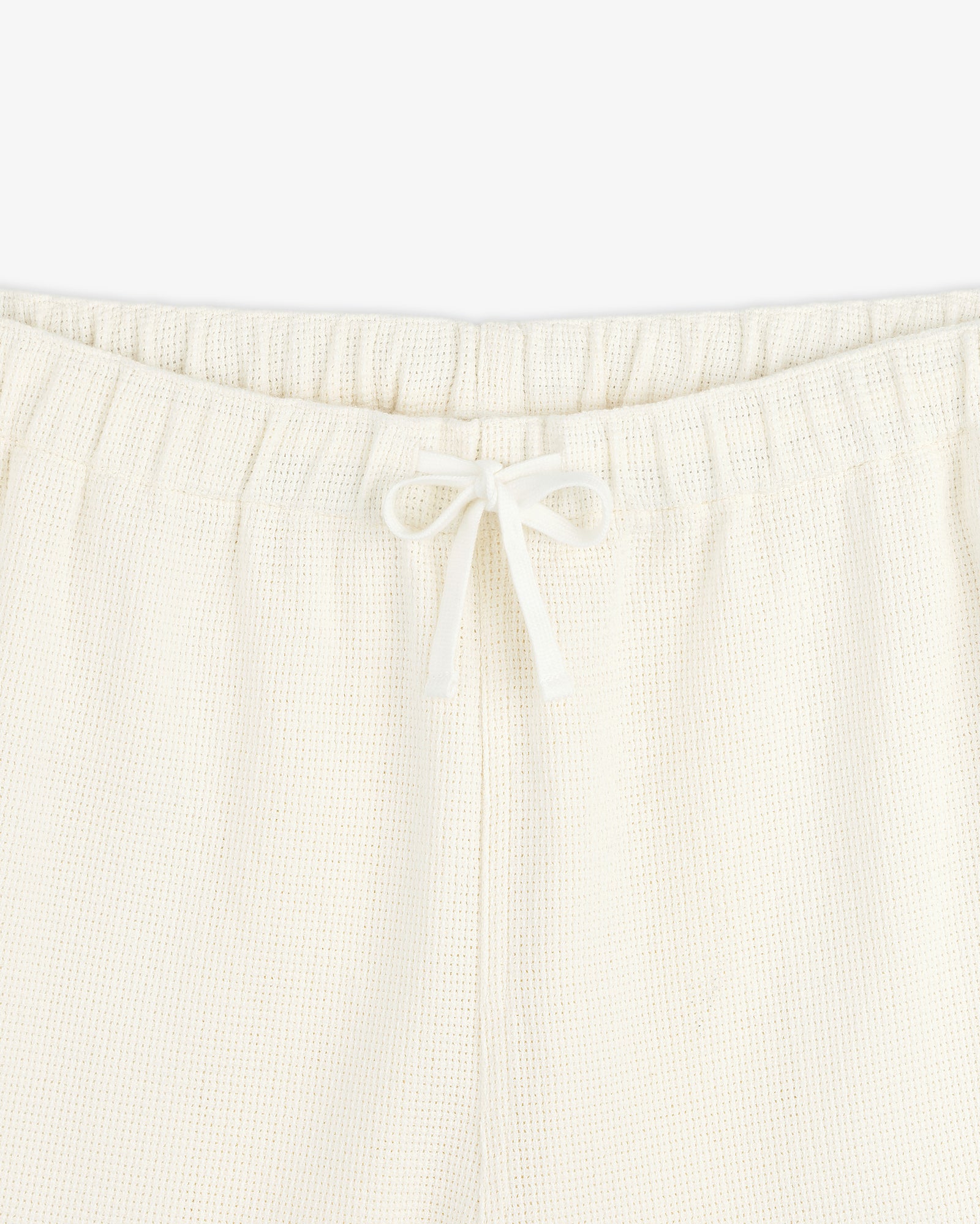 Close-up of Wide Leg Shore Pant in cream with an elastic waistband and front drawstring tied in a bow.