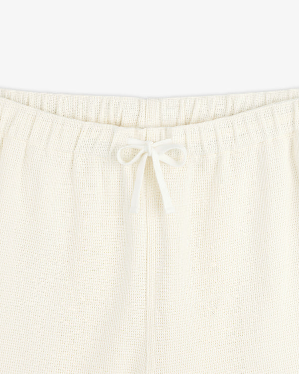 Close-up of Wide Leg Shore Pant in cream with an elastic waistband and front drawstring tied in a bow.