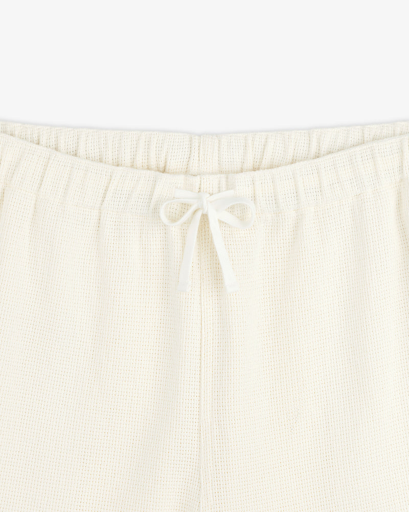 Close-up of Wide Leg Shore Pant in cream with an elastic waistband and front drawstring tied in a bow.
