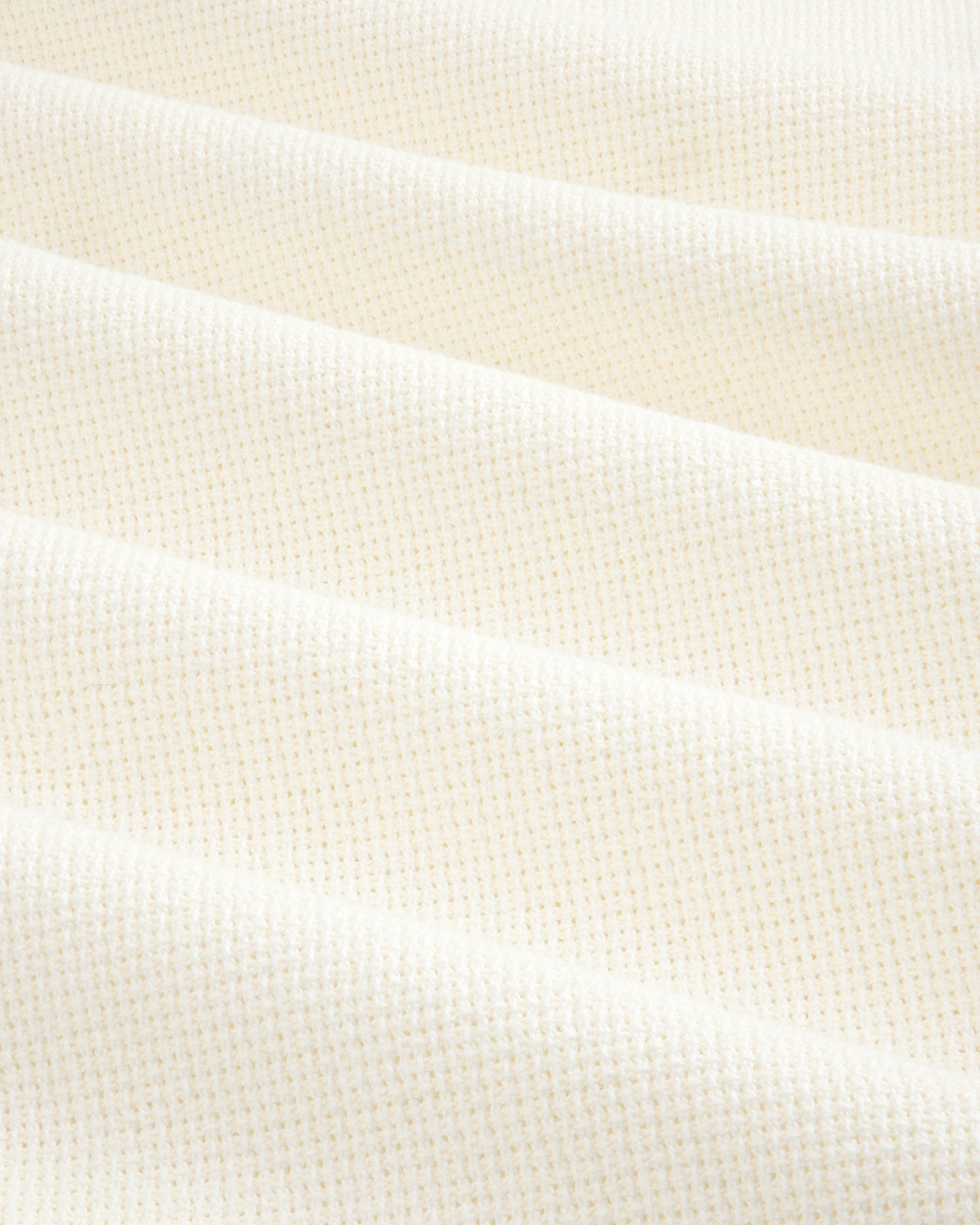 Wide Leg Shore Pant in cream-colored textured fabric with a small grid pattern, shown in soft, diagonal folds.