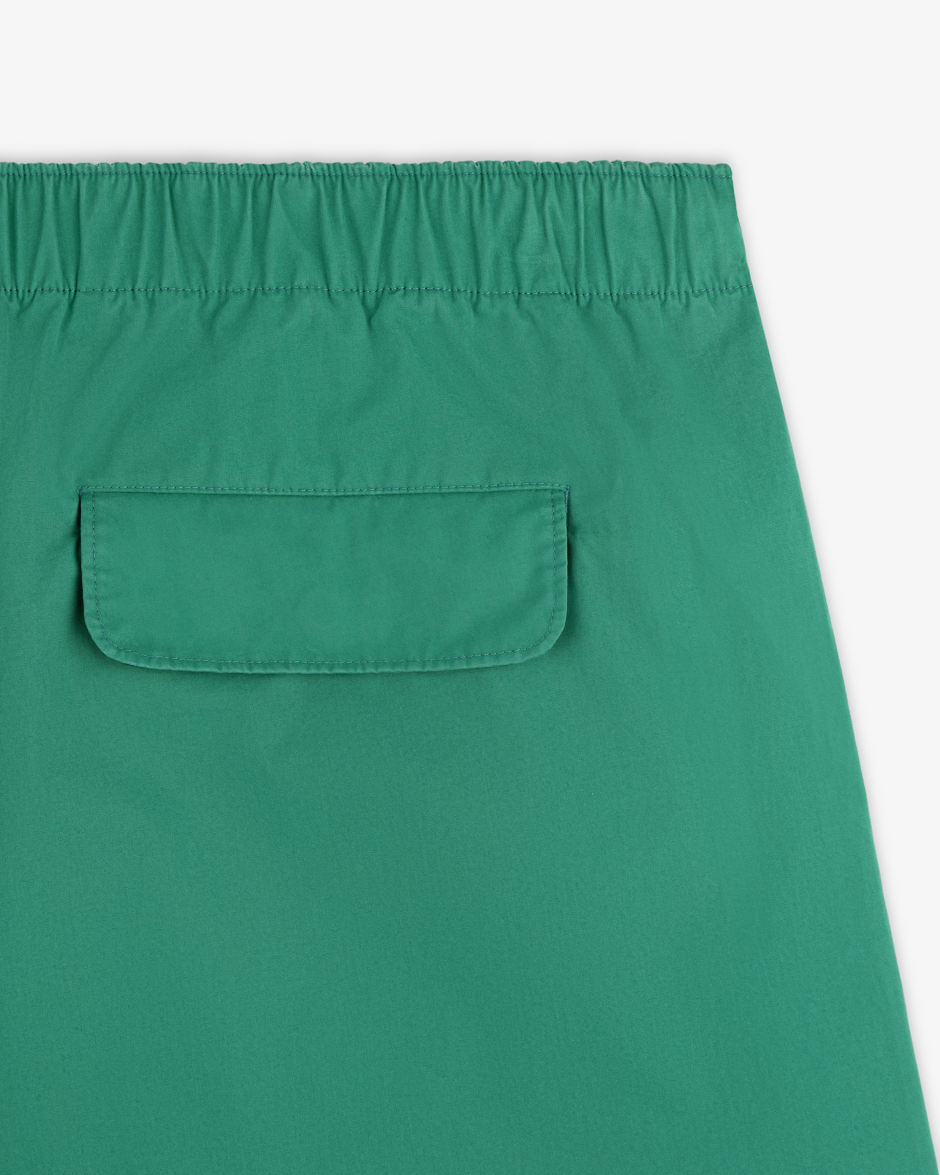 Close-up of Washed Cotton Windbreaker Pant in green with an elastic waistband and a back flap pocket.