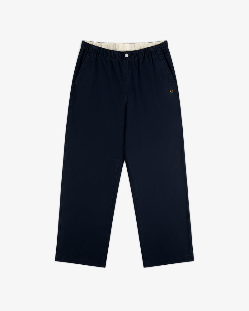 Washed Cotton Windbreaker Pant in navy with wide legs, elastic waist, side pockets, and embroidered logo by left pocket.