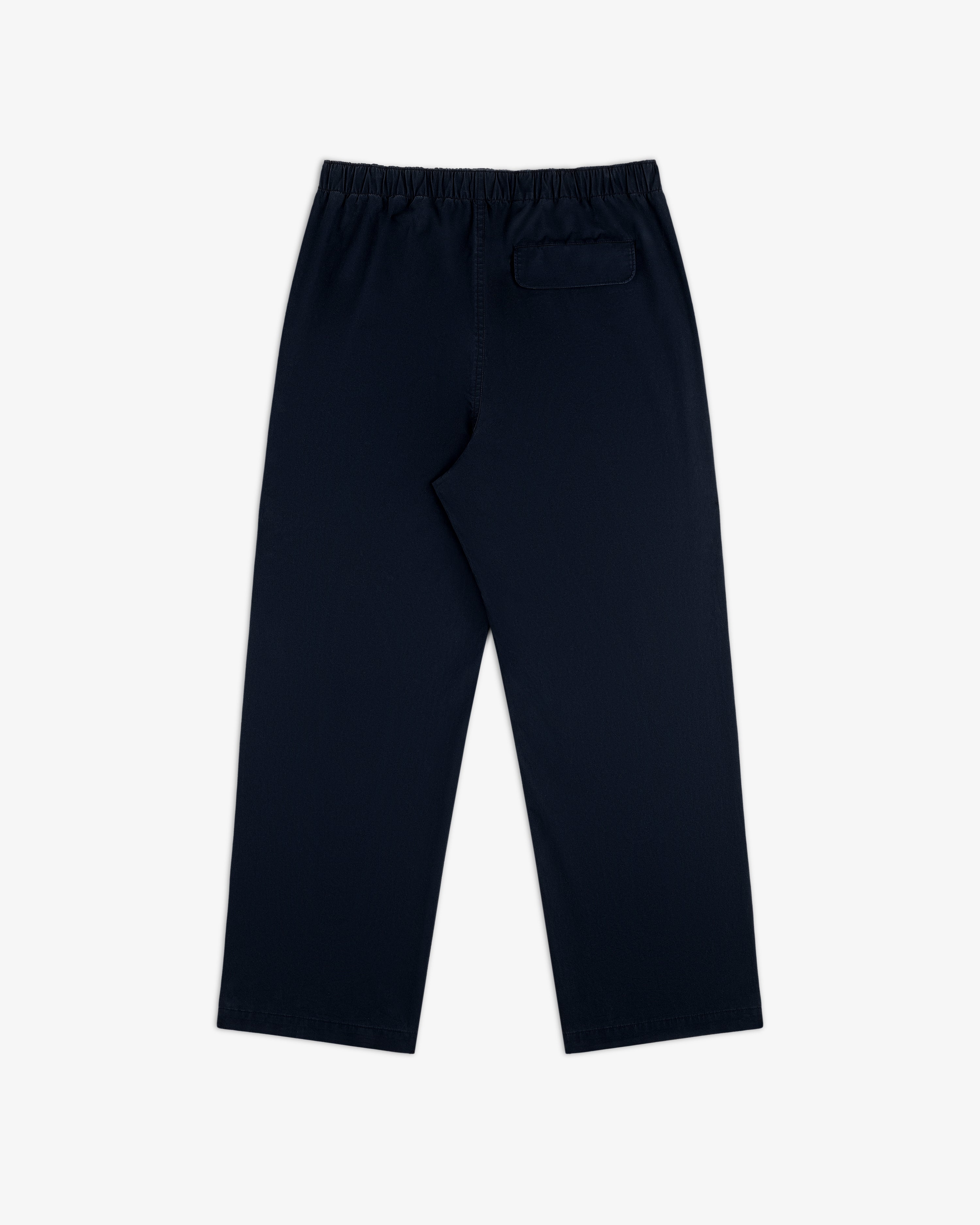 Washed Cotton Windbreaker Pant in navy blue with elastic waistband and a single back pocket, on white background.