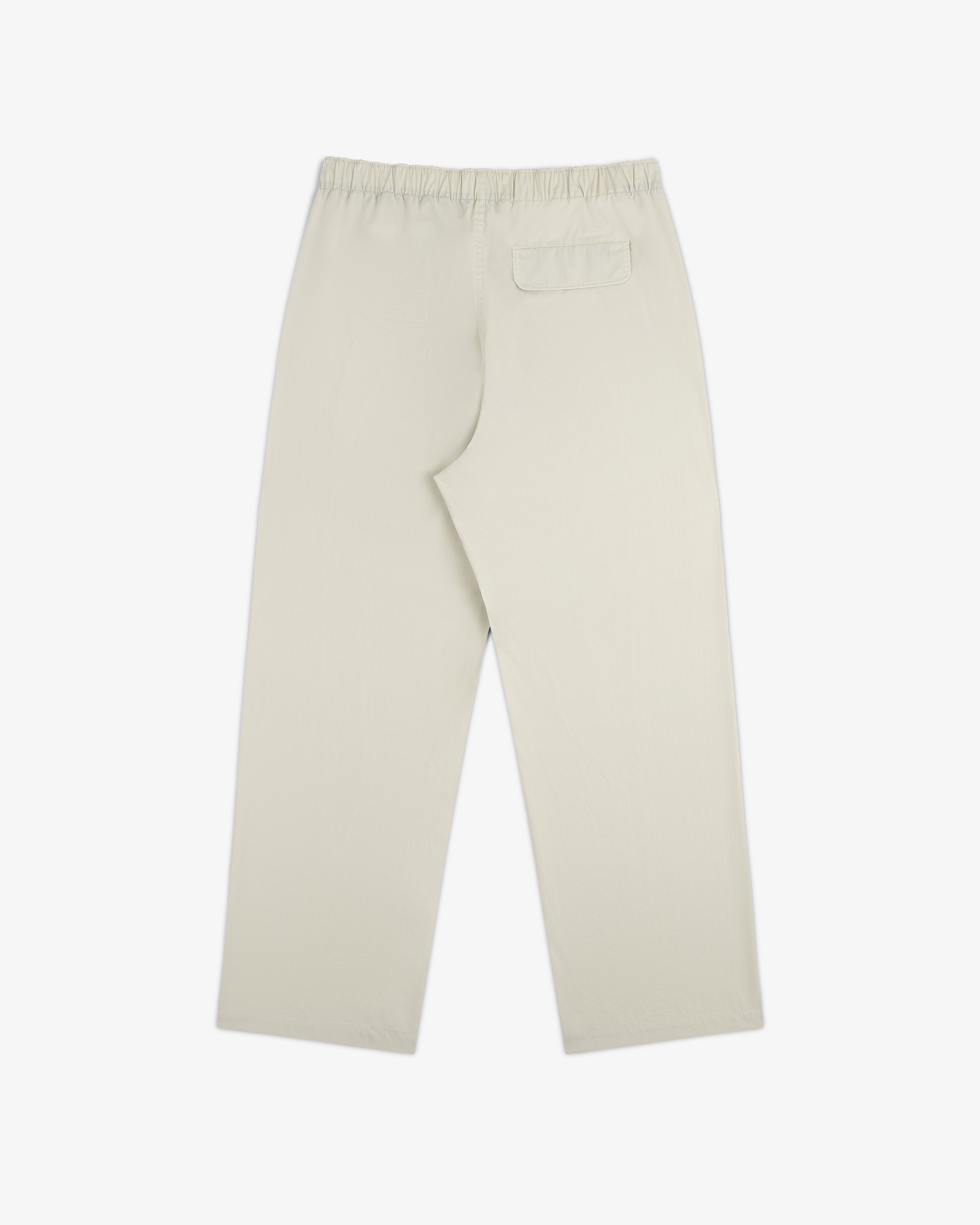 Washed Cotton Windbreaker Pant in beige with elastic waistband and one back pocket, shown flat on white.