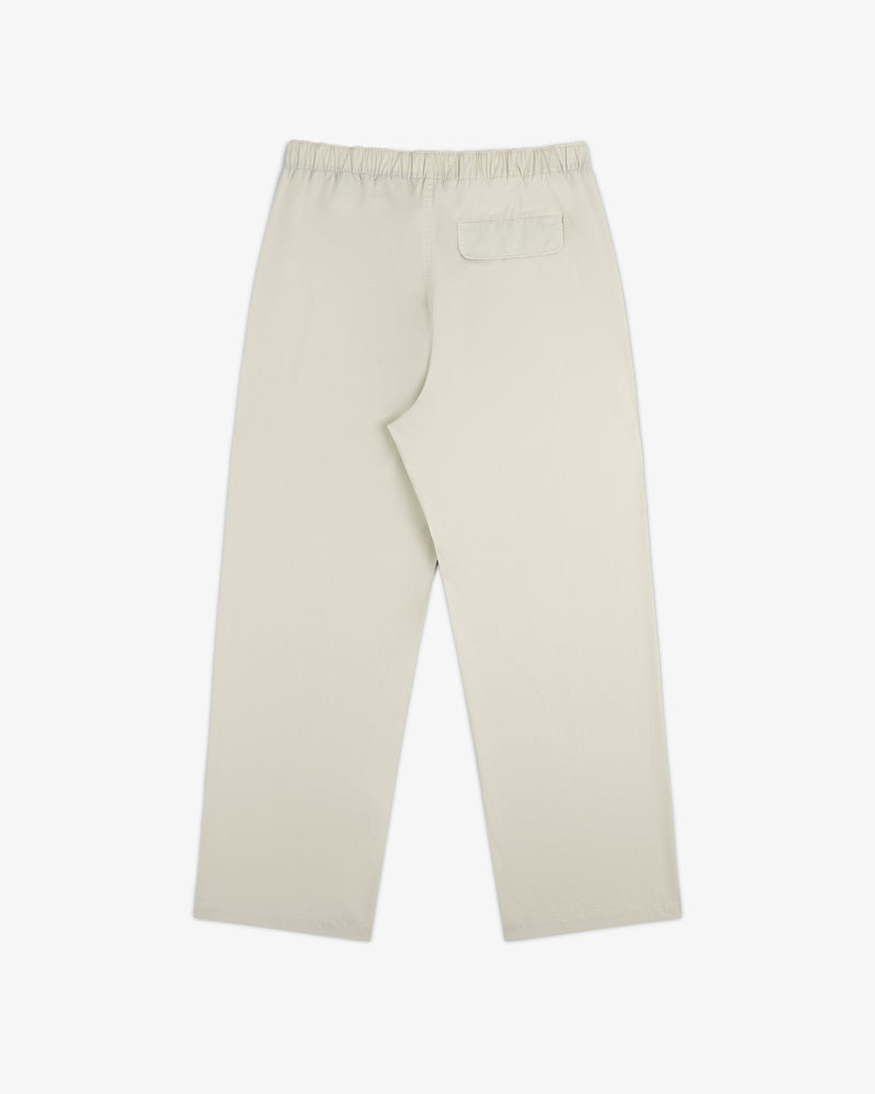 Washed Cotton Windbreaker Pant in beige with elastic waistband and one back pocket, shown flat on white.
