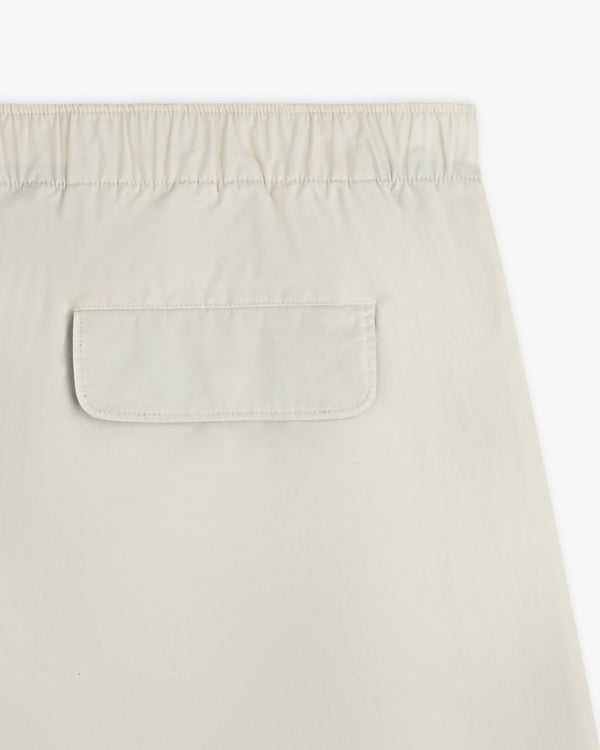 Close-up of the Washed Cotton Windbreaker Pant in beige, featuring an elastic waistband and back flap pocket.