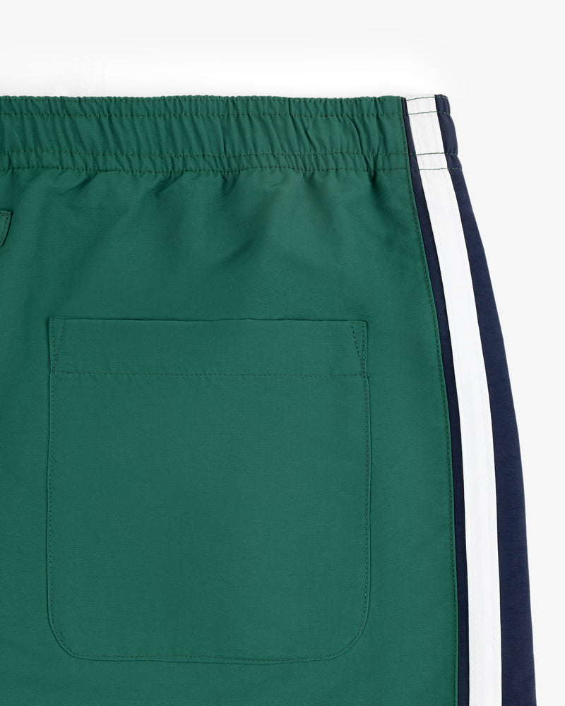 Close-up of Colorblock Track Pant in green with elastic waistband, back pocket, and navy-white side stripes.