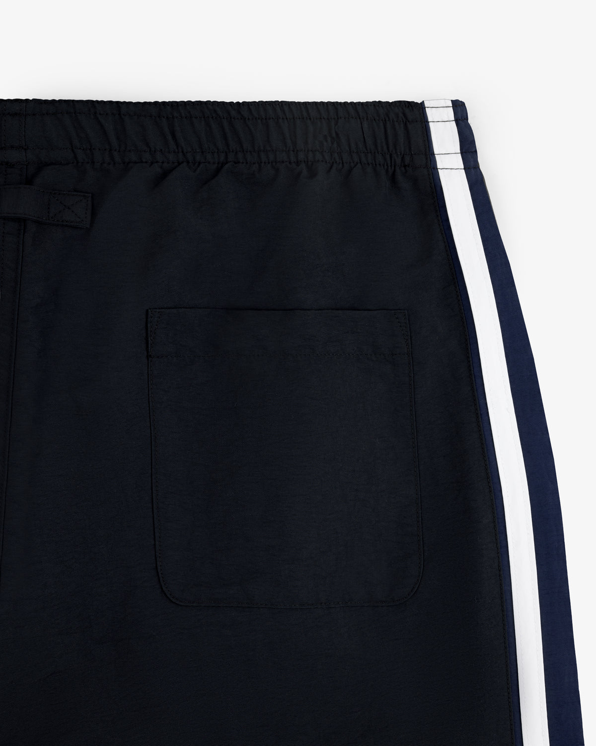 Close-up of Colorblock Track Pant in black, featuring a back pocket and white side stripe.