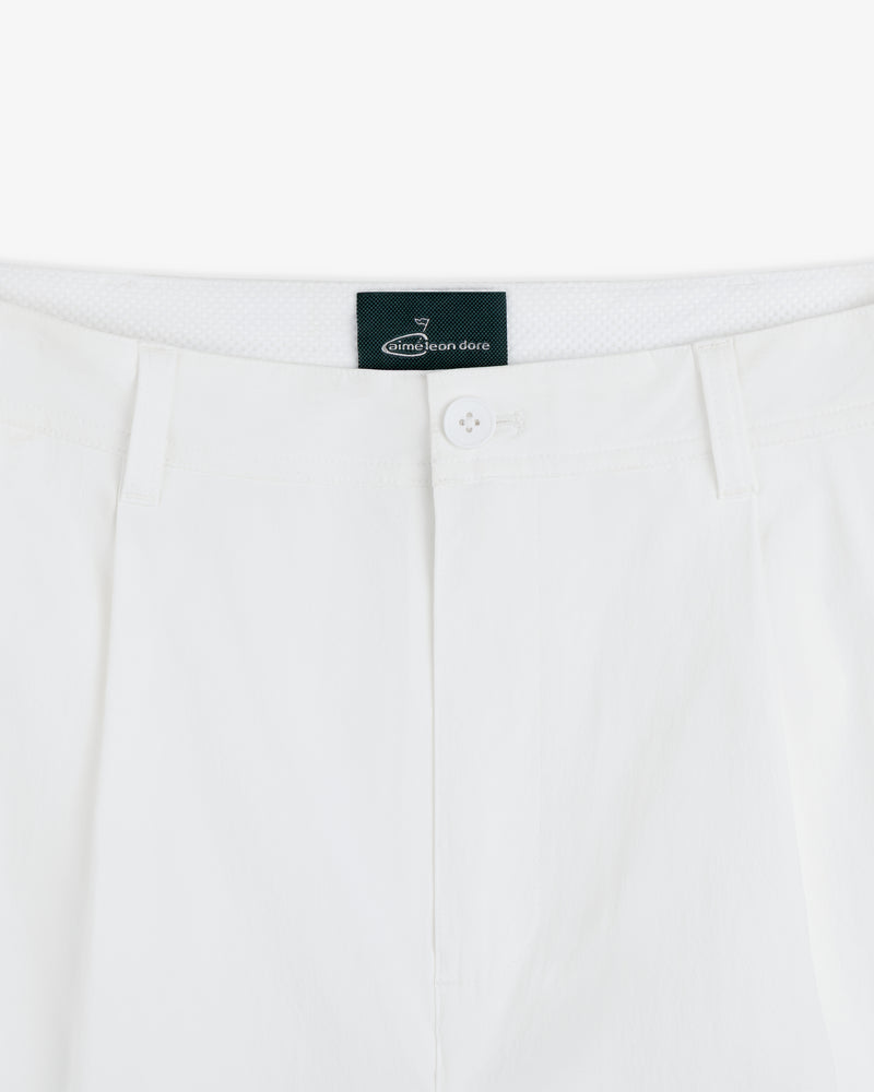 Close-up of the waistband and button of white ALD Golf Cordura Double Pleated Pant with black Aimé Leon Dore label inside.