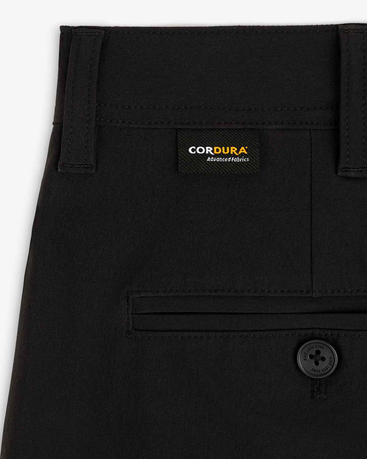 Close-up of ALD Golf Cordura Double Pleated Pant with Cordura label and single back pocket with black button.