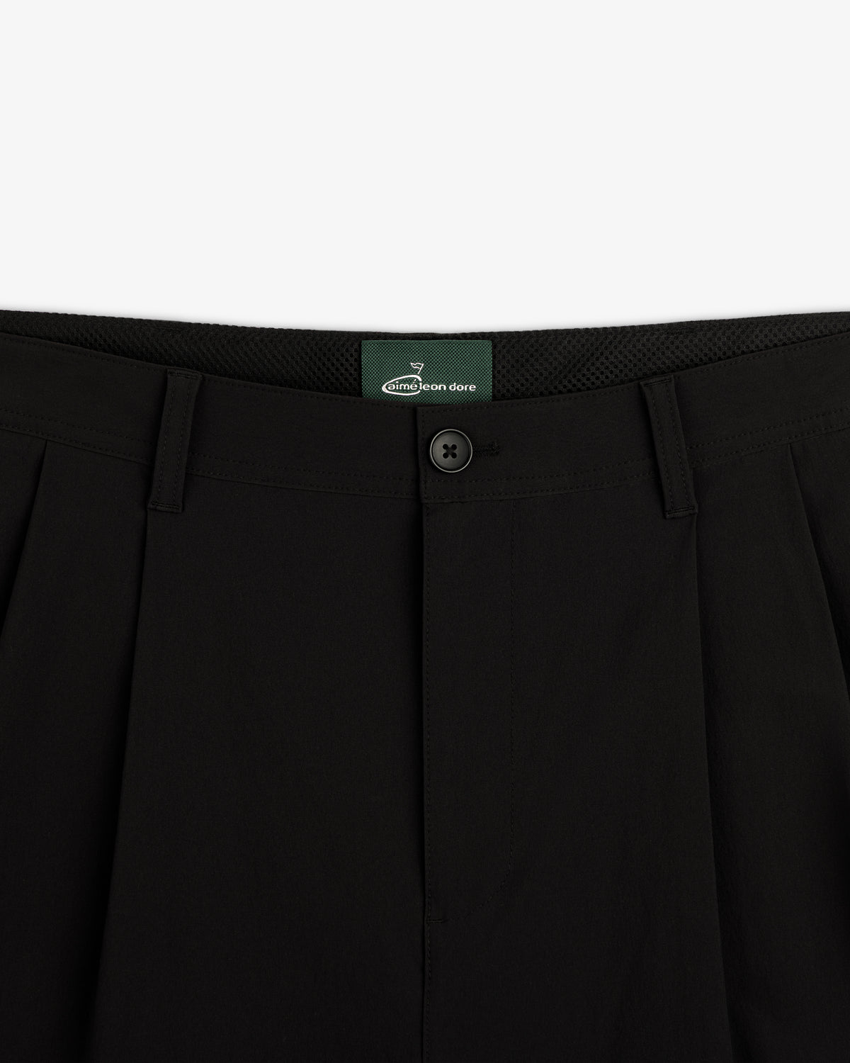 Close-up of waistband and button closure on ALD Golf Cordura Double Pleated Pant with green inner label.