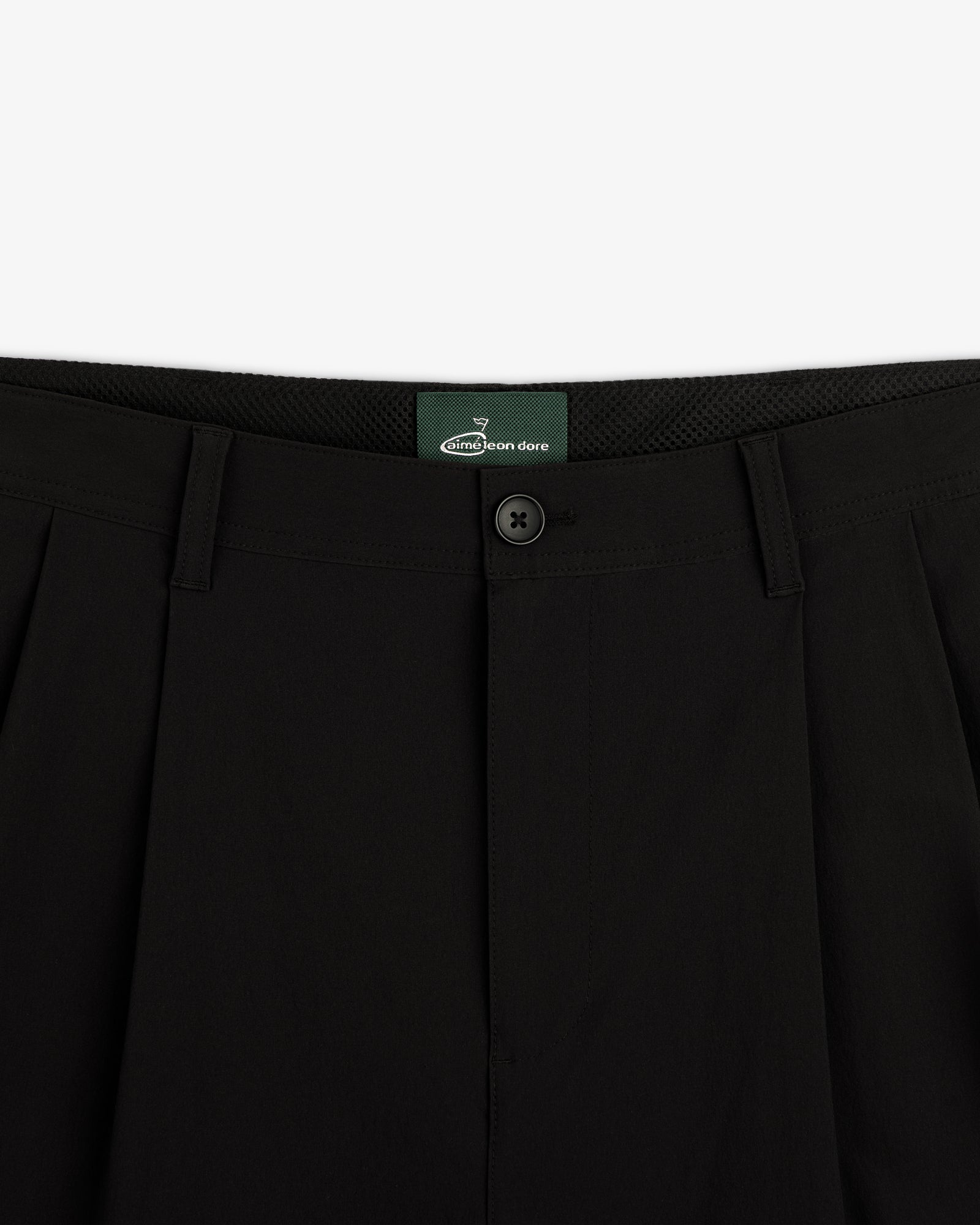 Close-up of waistband and button closure on ALD Golf Cordura Double Pleated Pant with green inner label.