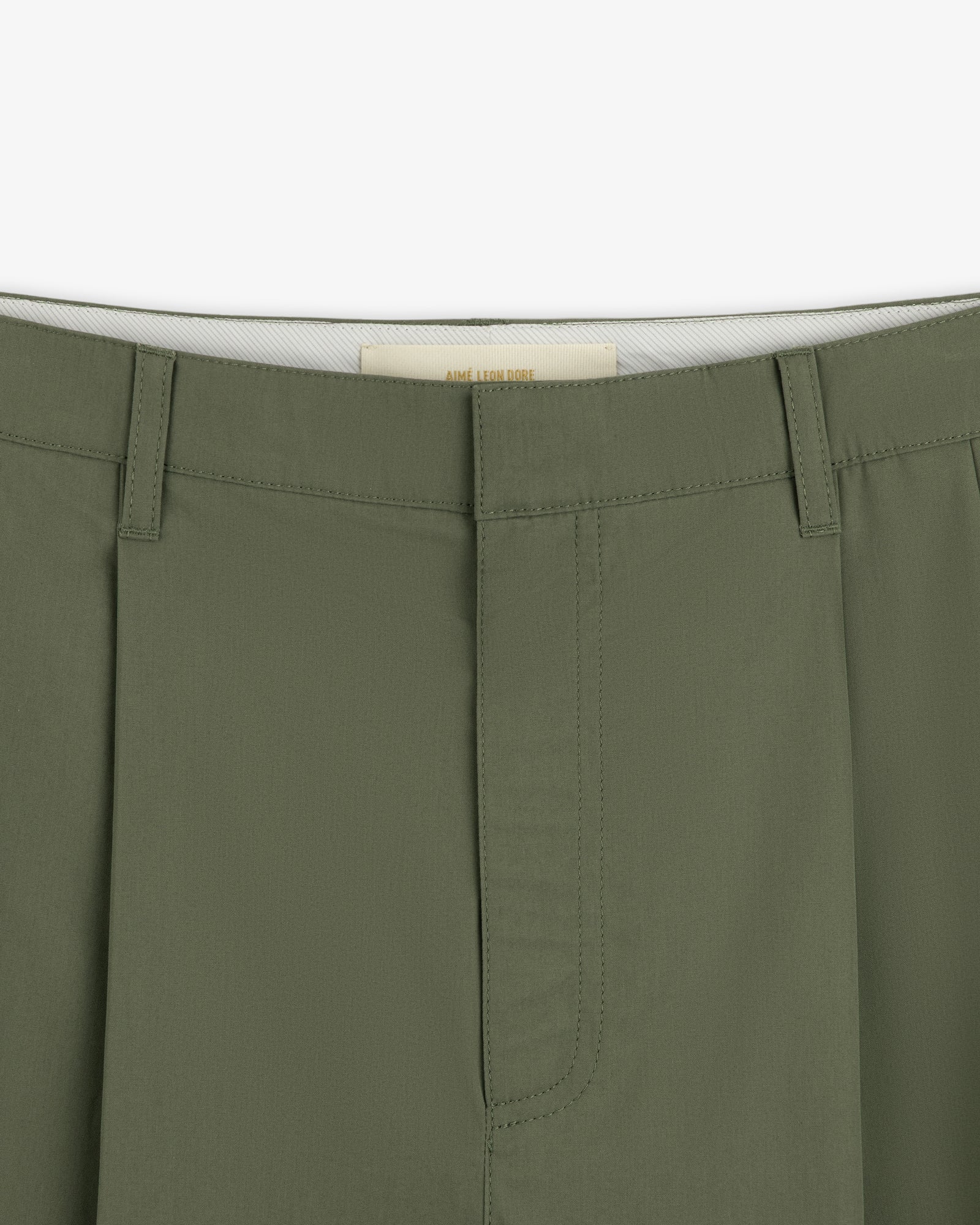 Close-up of the waistband and fly of Lightweighted Pleated Cotton Trouser with belt loops and visible stitching.