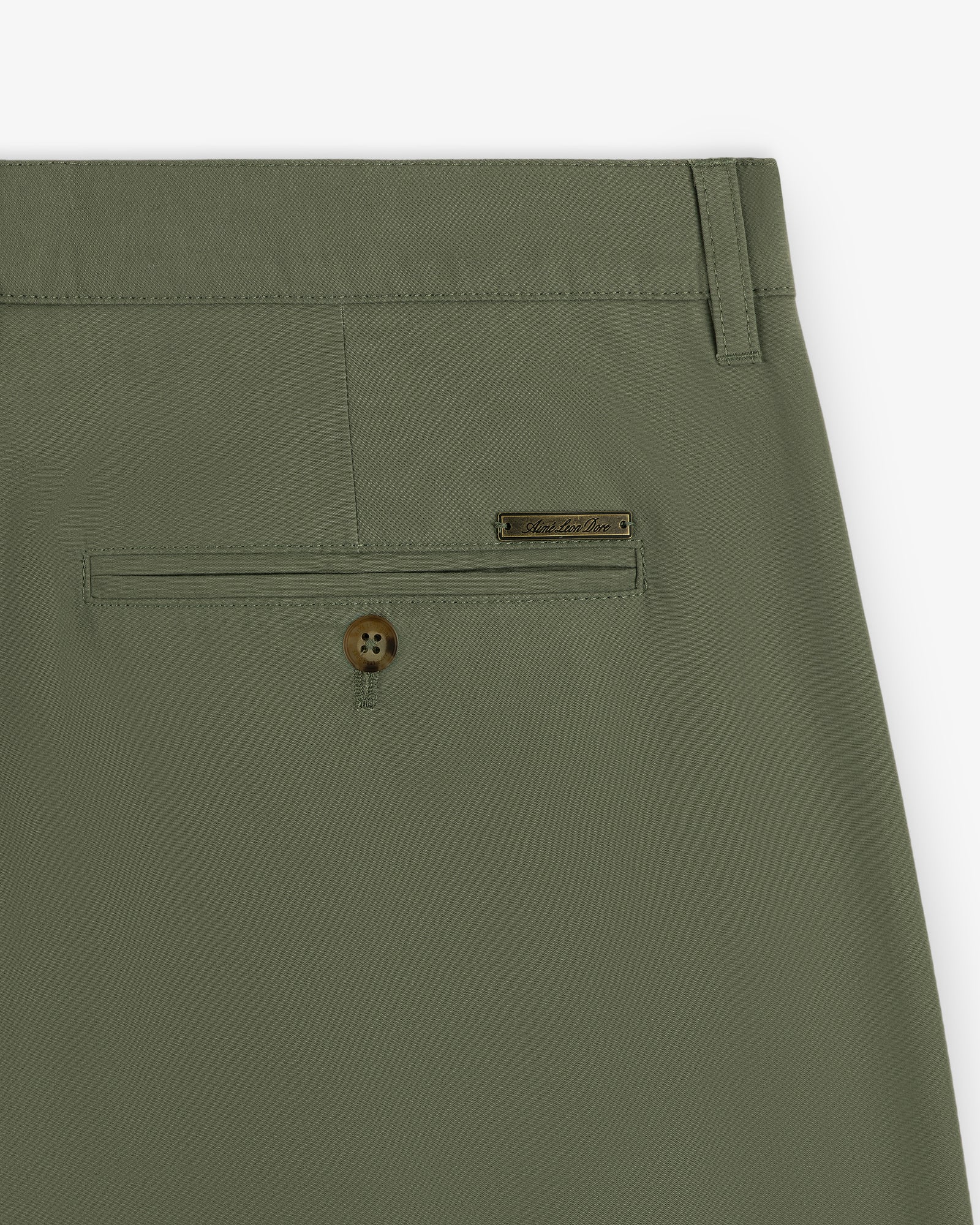 Close-up of Lightweighted Pleated Cotton Trouser in olive green with a buttoned back pocket and metallic brand tag.