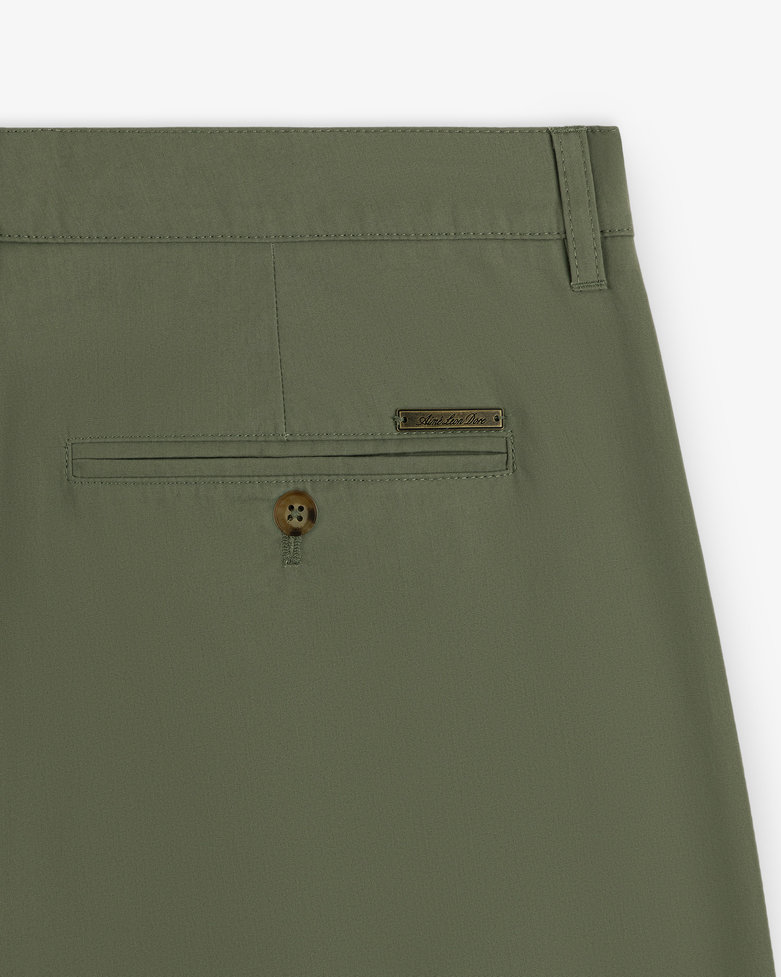 Close-up of Lightweighted Pleated Cotton Trouser in olive green with a buttoned back pocket and metallic brand tag.