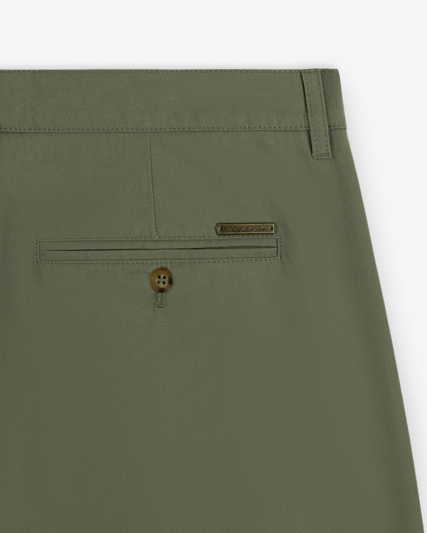 Close-up of Lightweighted Pleated Cotton Trouser in olive green with a buttoned back pocket and metallic brand tag.