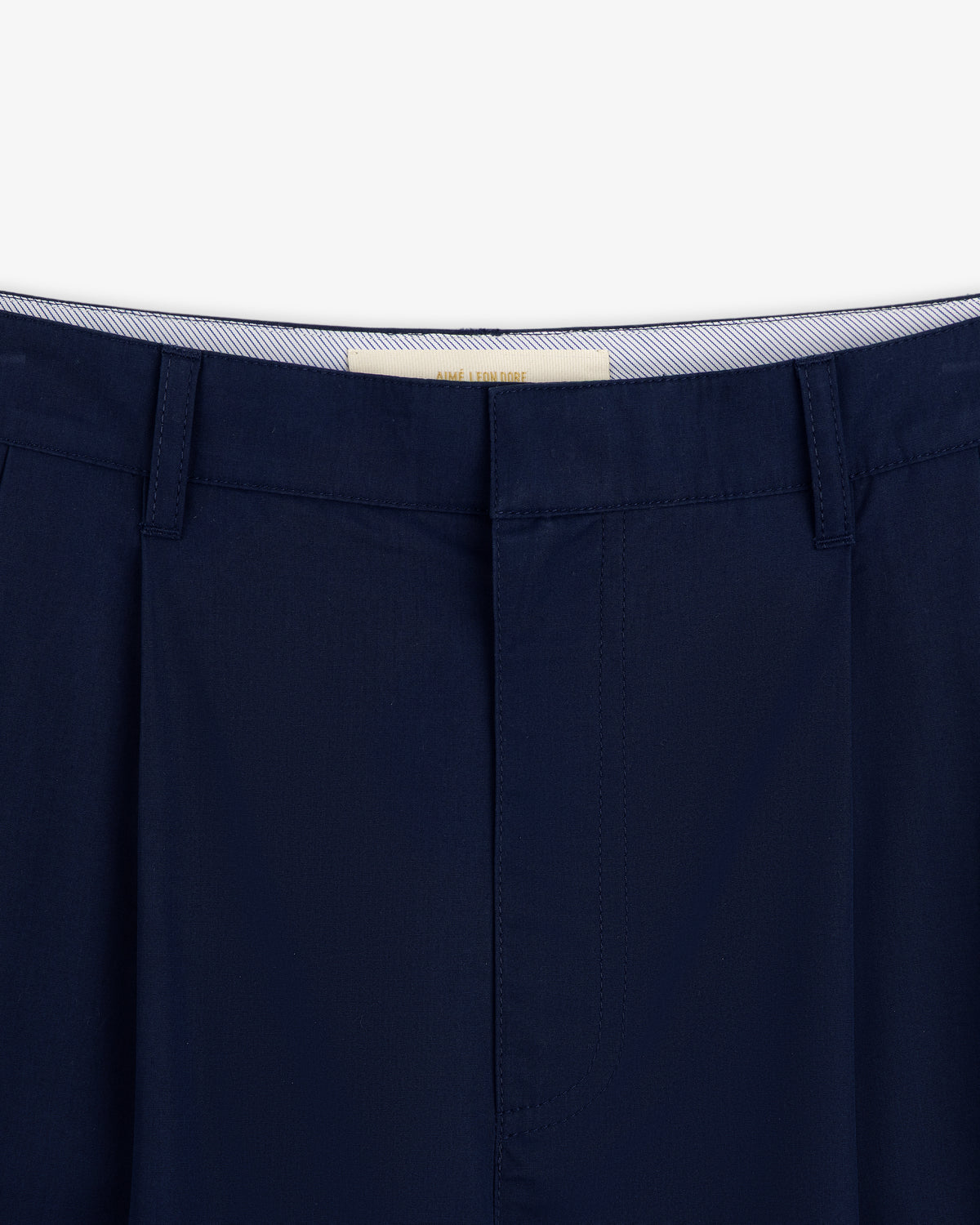 Close-up of Lightweighted Pleated Cotton Trouser in navy with belt loops and a striped inner waistband.
